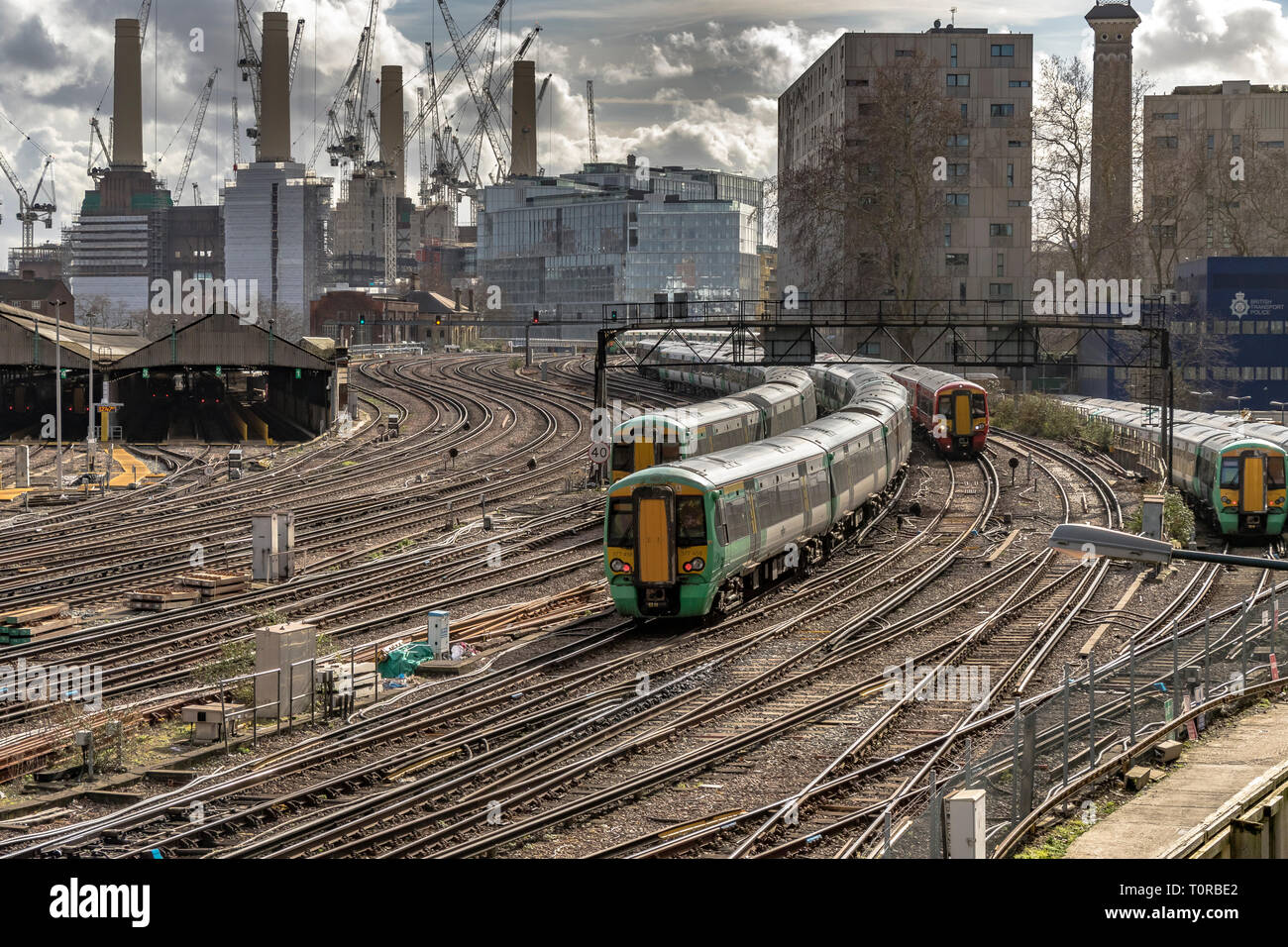 Southern Rail train approaching Ebury Bridge on the final approach to Victoria Station ,with Battersea Power Station in the distance ,London, UK Stock Photo