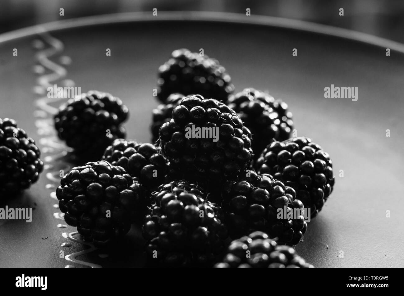 large juicy fresh blackberry berries on a ceramic plate, close-up Stock Photo