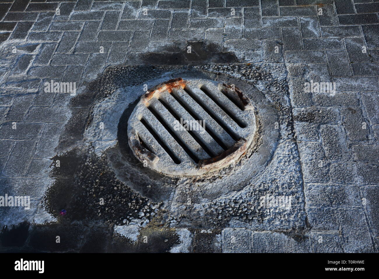 Road drain cover/ manhole covered with Silica sinter, Rotorua, New Zealand Stock Photo