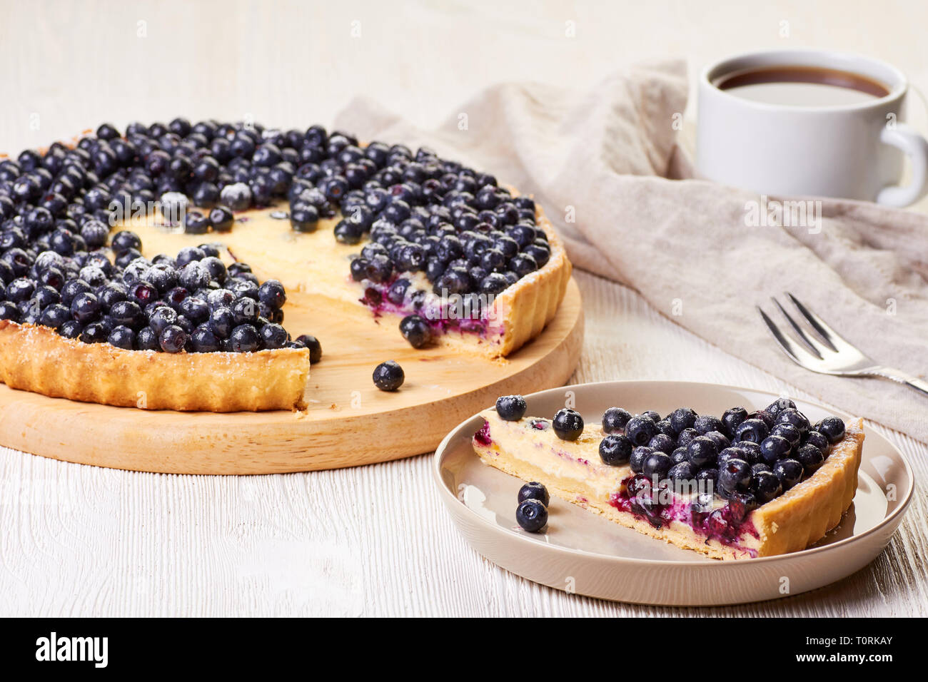 Homemade custard tart with blueberries on white wooden table Stock Photo