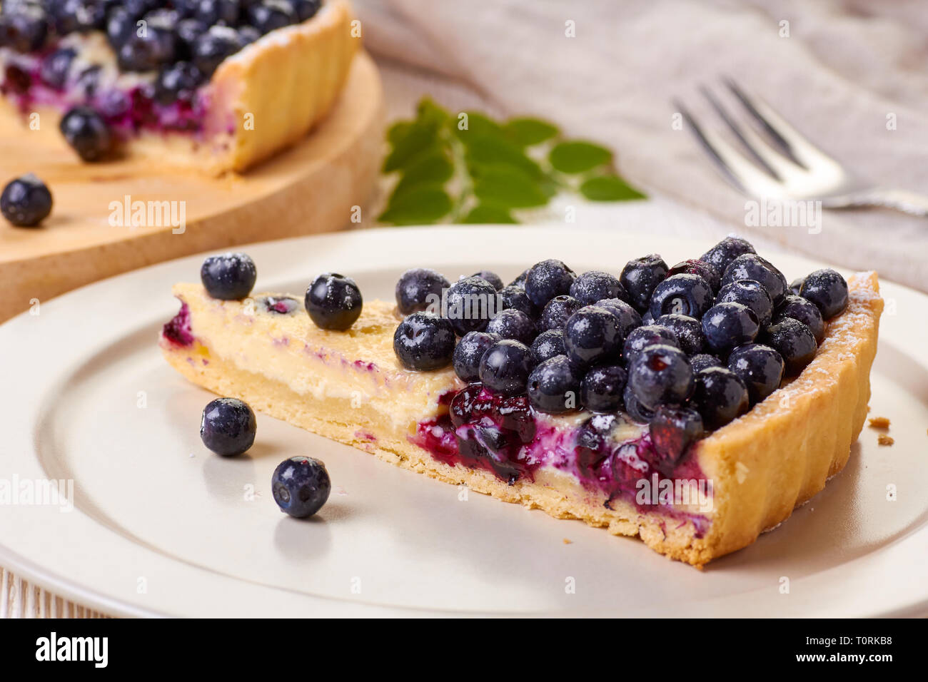 Piece of  custard tart with blueberries on dish Stock Photo