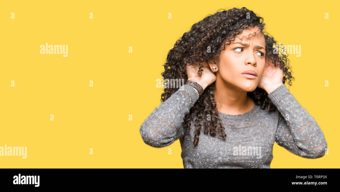 Young Beautiful Woman With Curly Hair Wearing Grey Sweater