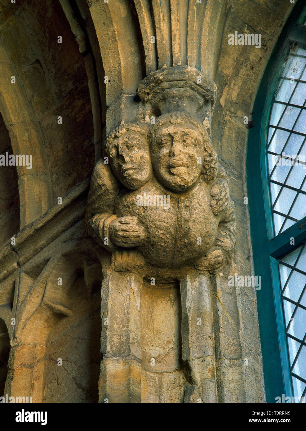 Tudor carving overlooking bathing pool in crypt of St Winifred's well chapel, Holywell, Flintshire, Wales, UK: a sick pilgrim being carried piggyback. Stock Photo