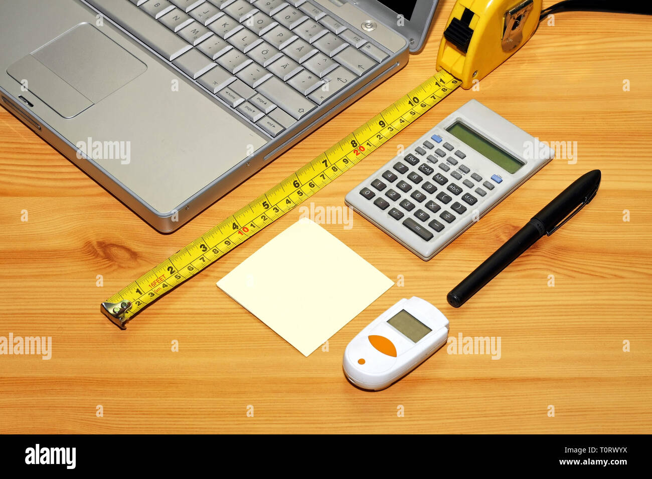 Notebook Measuring Tape And Calculator At Wooden Desk Stock Photo