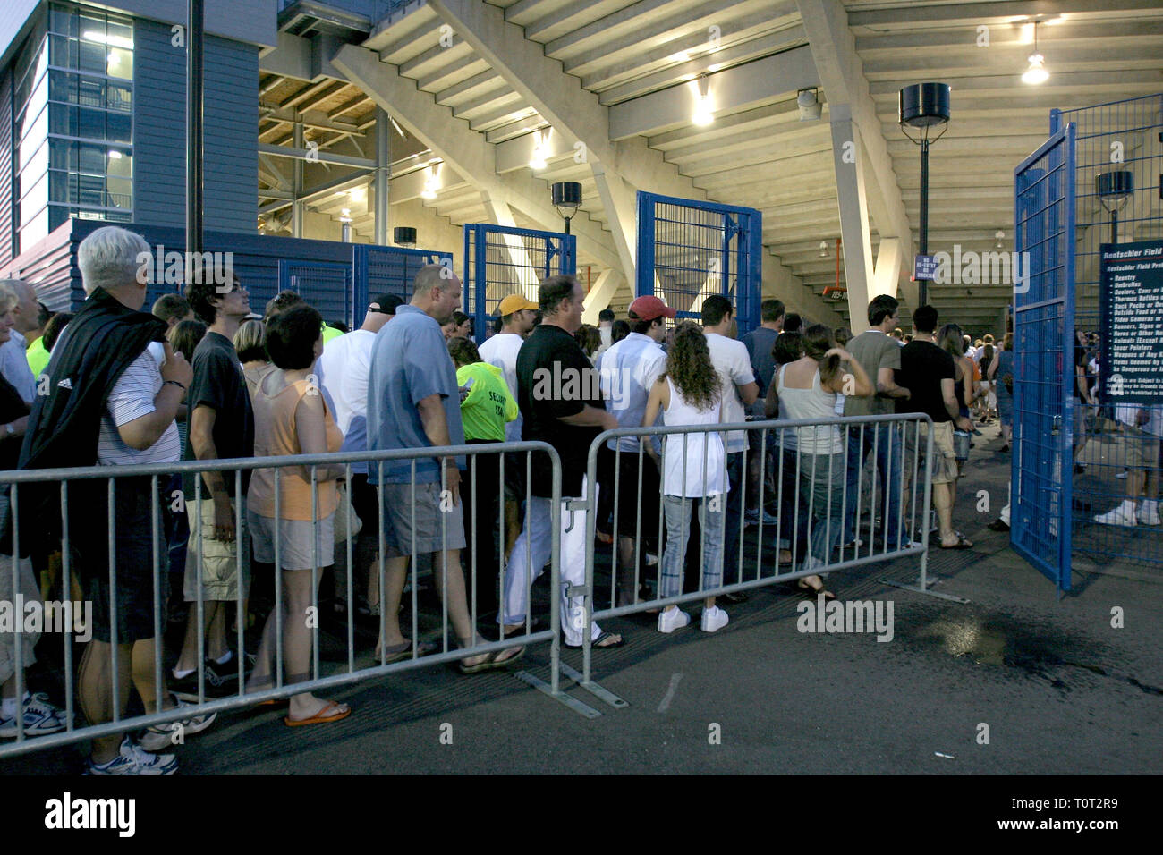 Concert fans are shown lined up at the entrance gate of a stadium event. Stock Photo