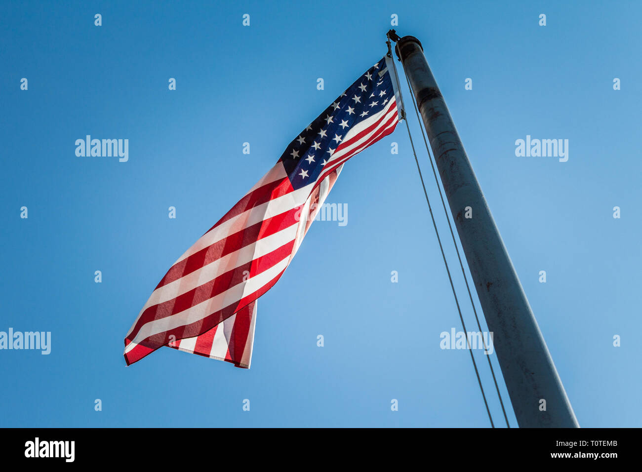 The American flag flying high on a bright, sunny day. Stock Photo
