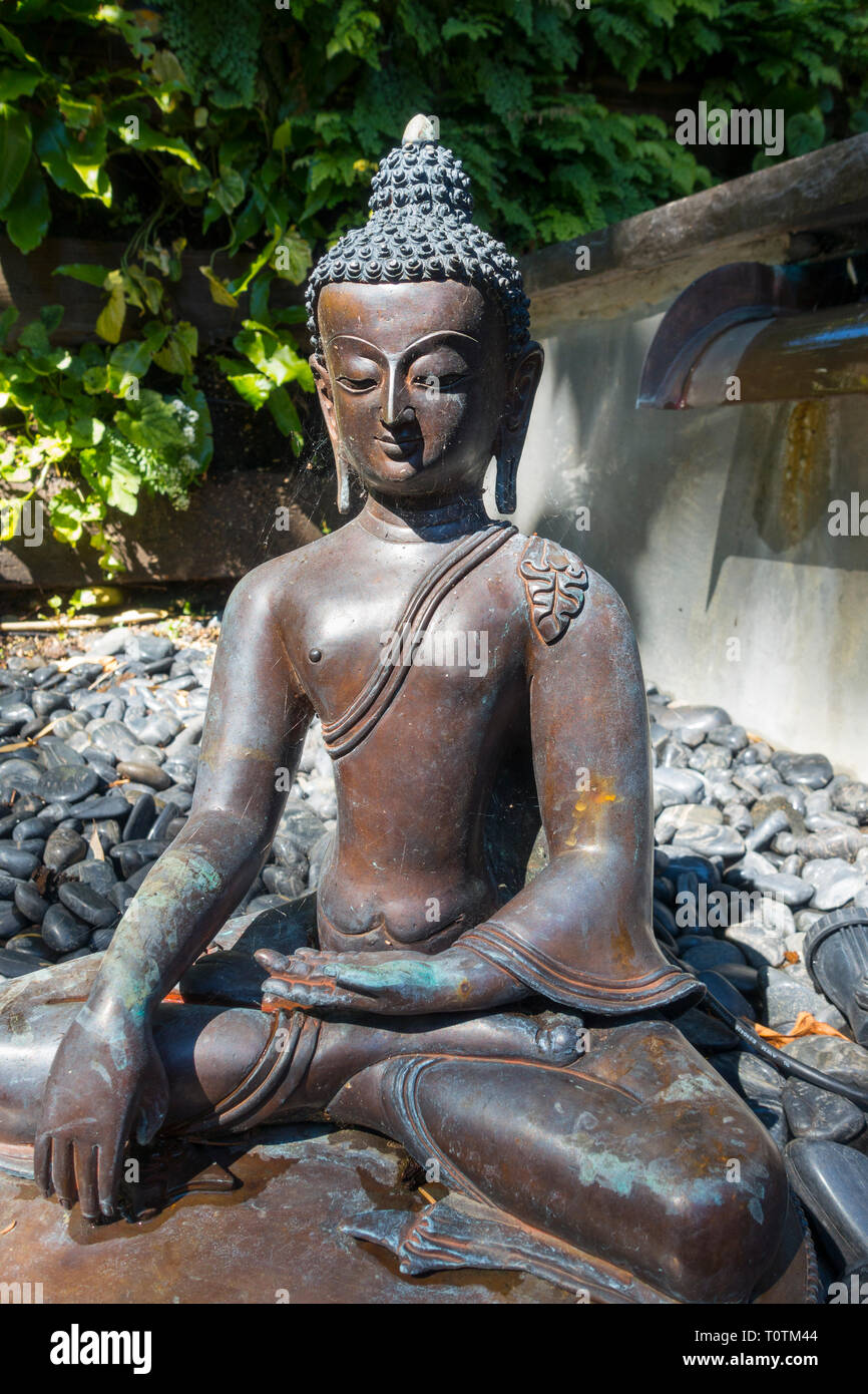 Seated buddha statue in a garden Stock Photo