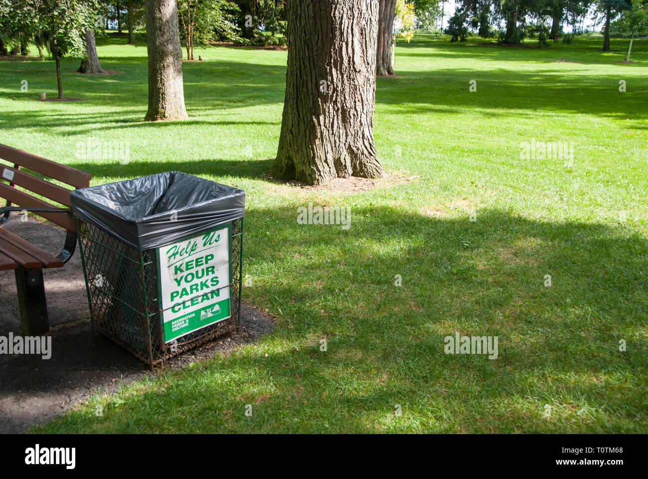 A metal litter bin in a Toronto park encouraging visitors to keep the area clean. Stock Photo