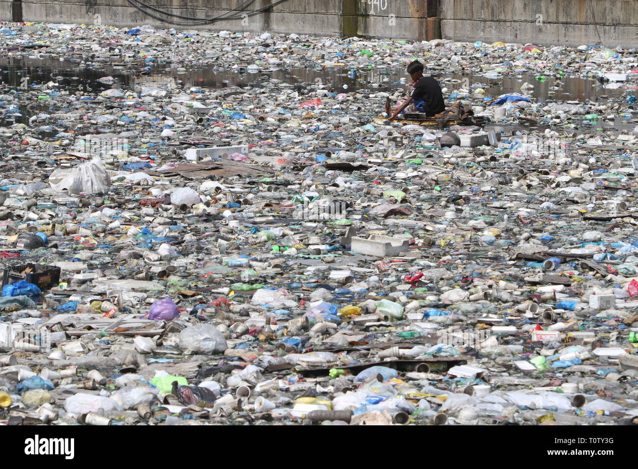A scavenger collects recyclable materials that can be sold to junkshops ...