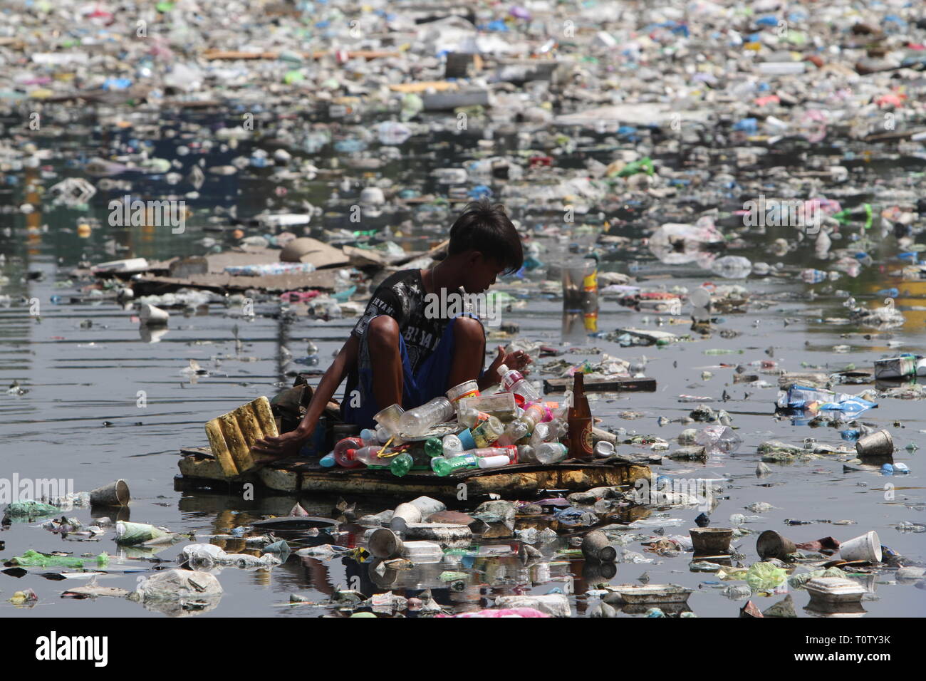 A scavenger collects recyclable materials that can be sold to junkshops ...