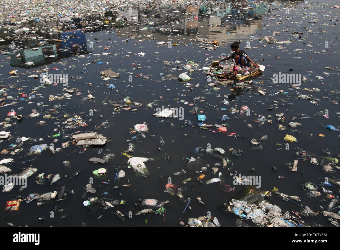 A scavenger collects recyclable materials that can be sold to junkshops ...