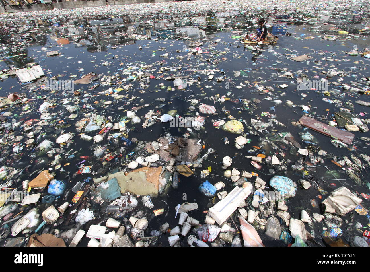 A scavenger collects recyclable materials that can be sold to junkshops ...