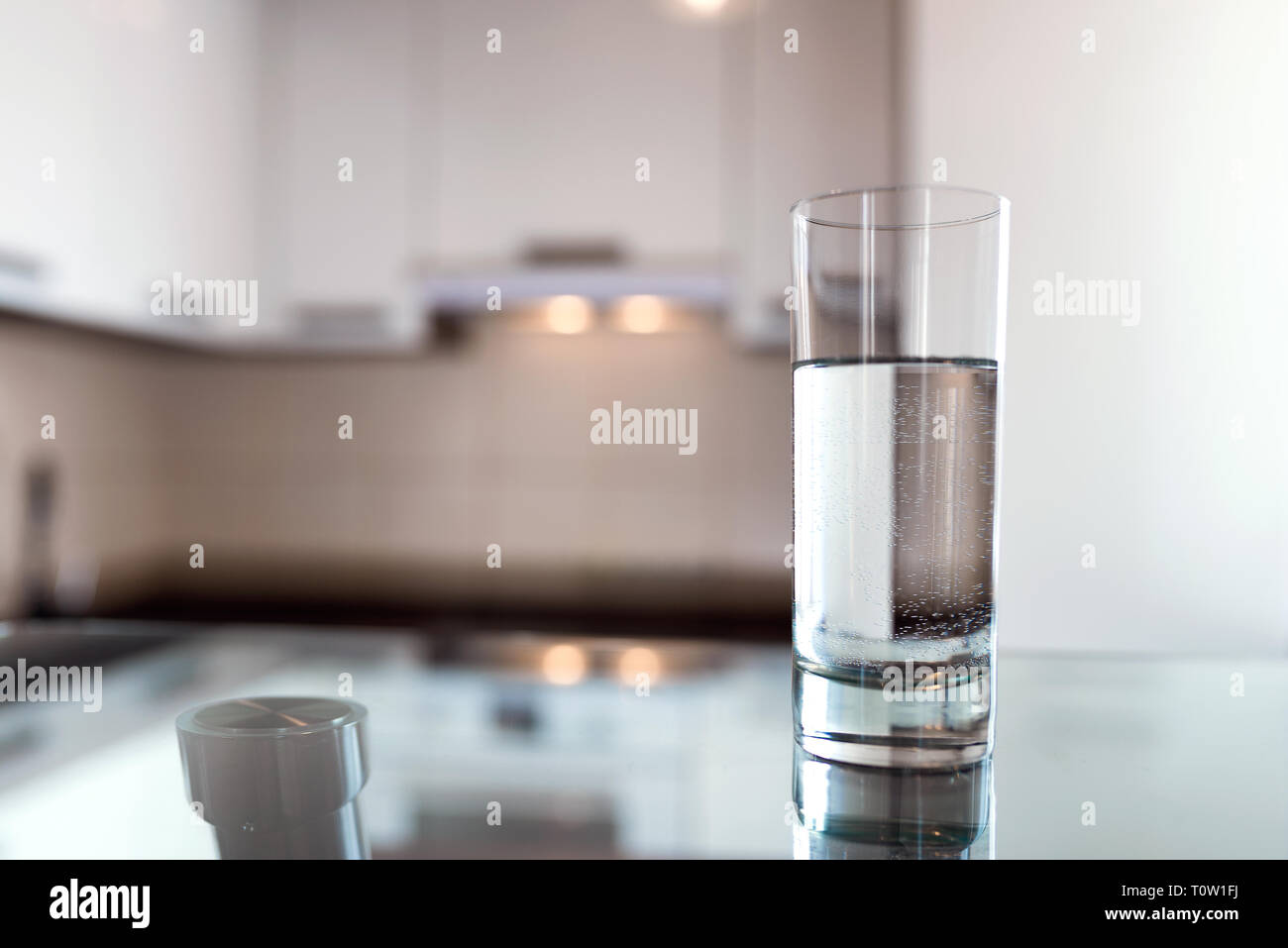 A glass of fresh water on the background of a modern kitchen. With copy space for your design. Stock Photo