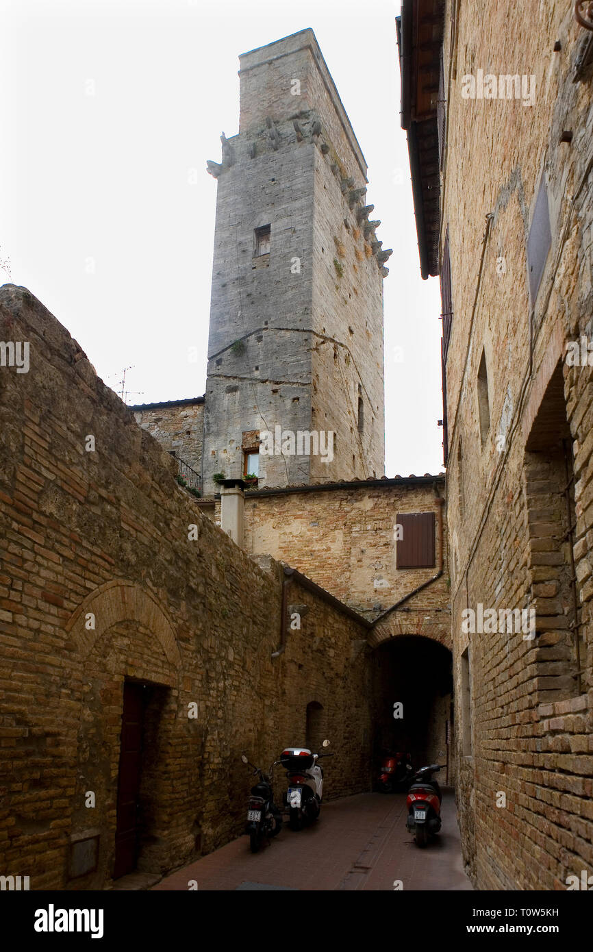 A misty morning, Vicolo dell'Oro, San Gimignano, with the Torre del Diavolo dominating: Tuscany, Italy Stock Photo