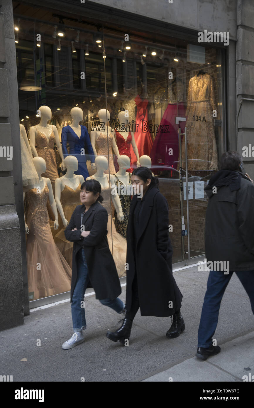 Women walk by a wholesale fashion outlet in the Garment District on the Westside of midtown Manhattan. Stock Photo