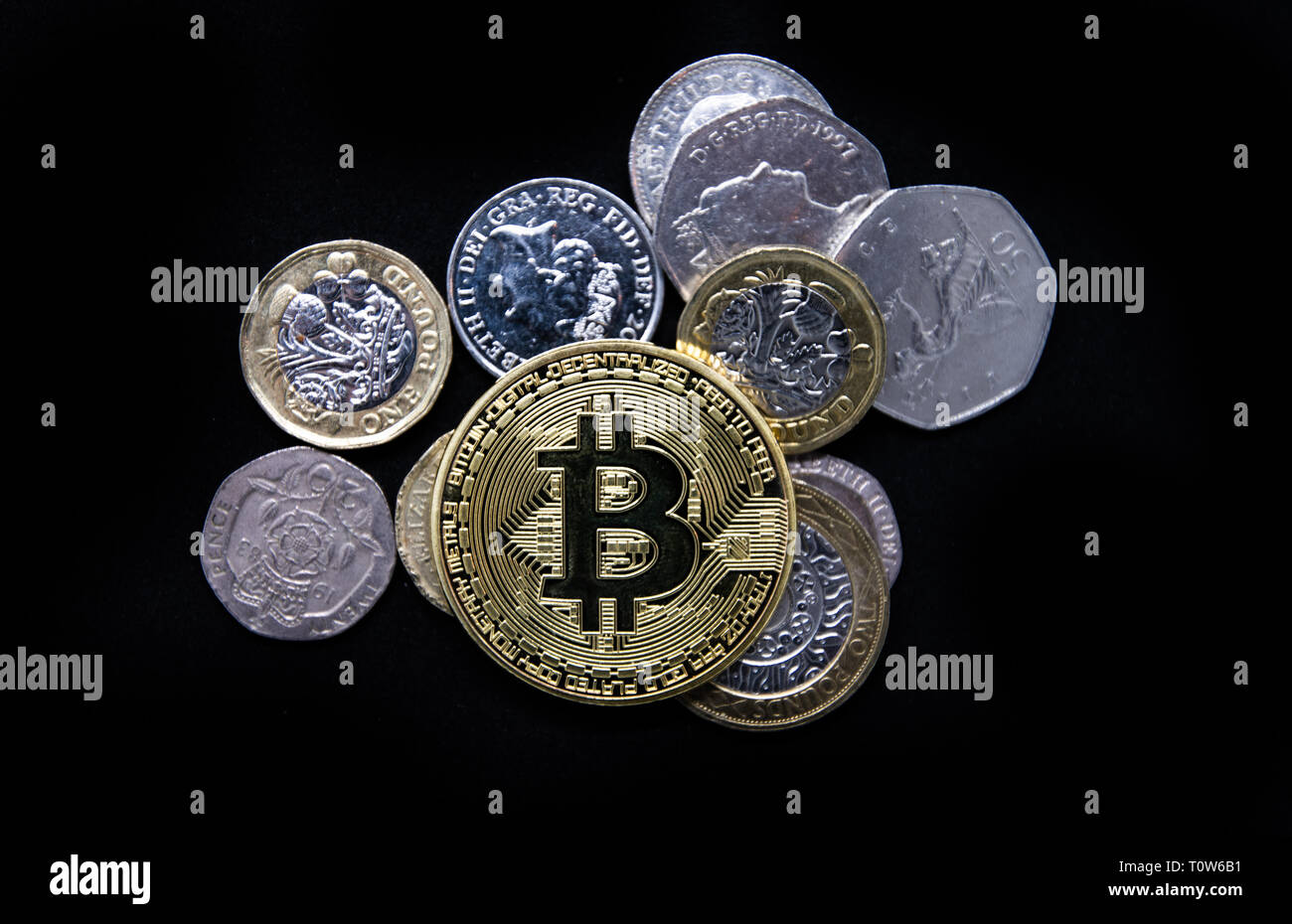 Physical gold Bitcoin laying on top of plain old English money Stock Photo  - Alamy