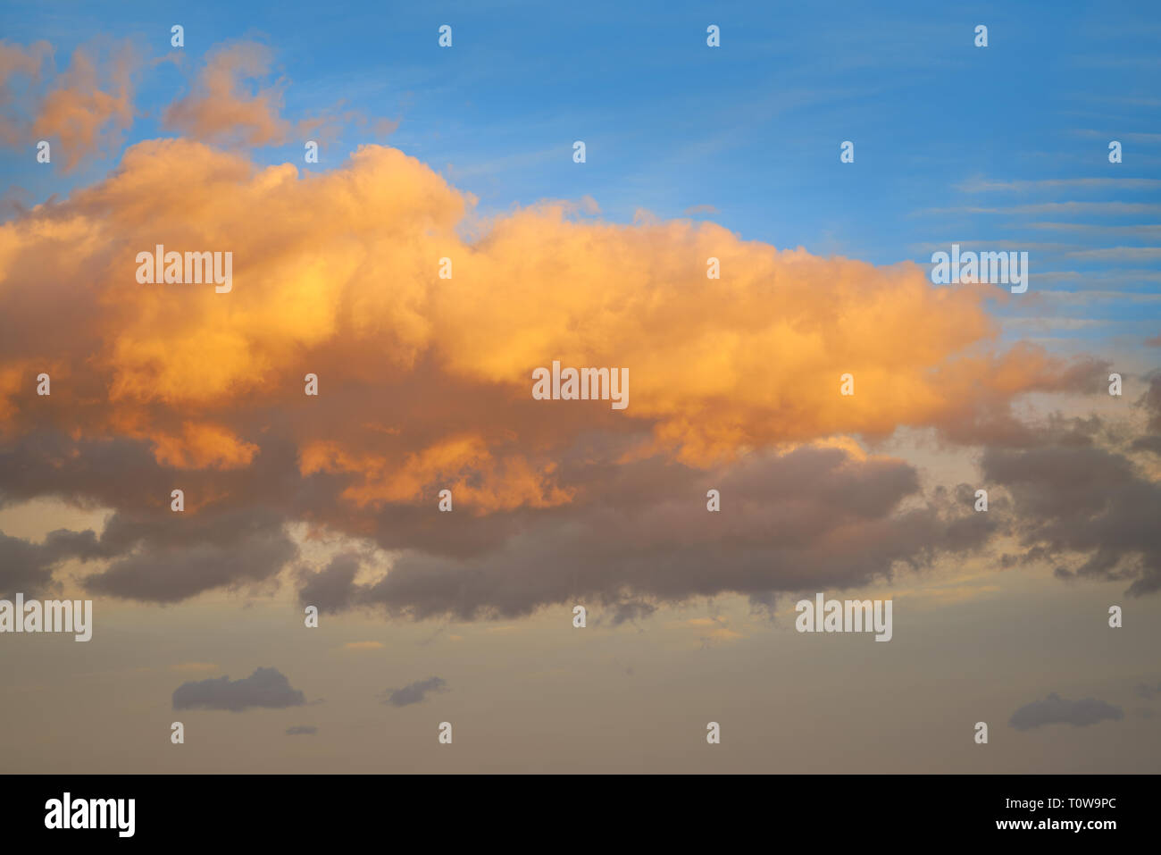 Sunset clouds in orange and blue sky background Stock Photo