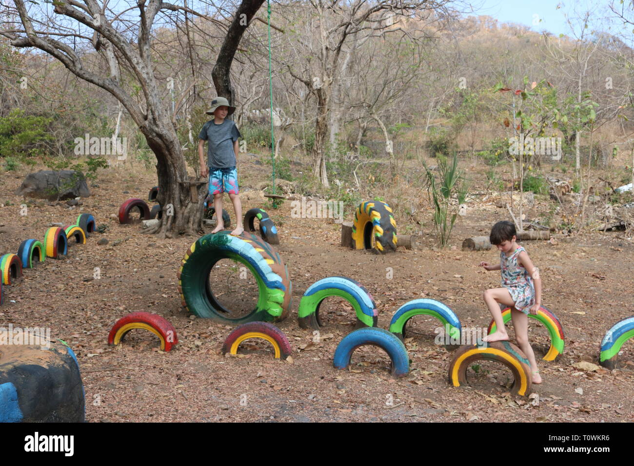 Children playing on a playground in Central America made of brightly painted recycled tires Stock Photo