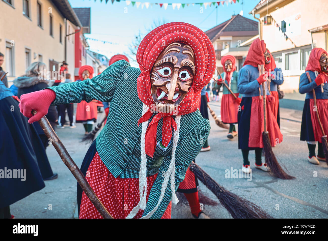 Pretty witch is holding a broom. Street Carnival in Southern Germany