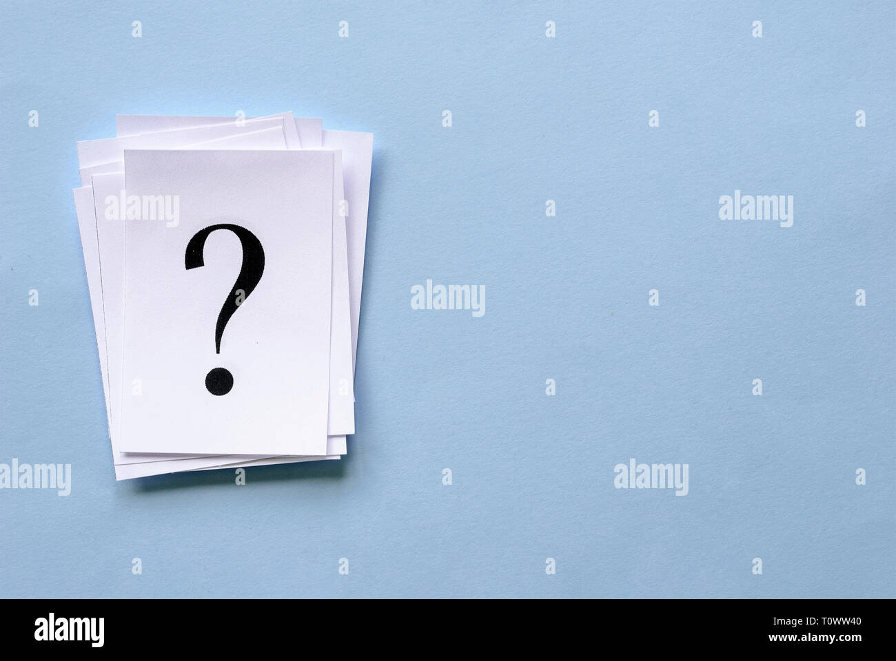 Pile of stacked question marks printed on sheets of white paper or