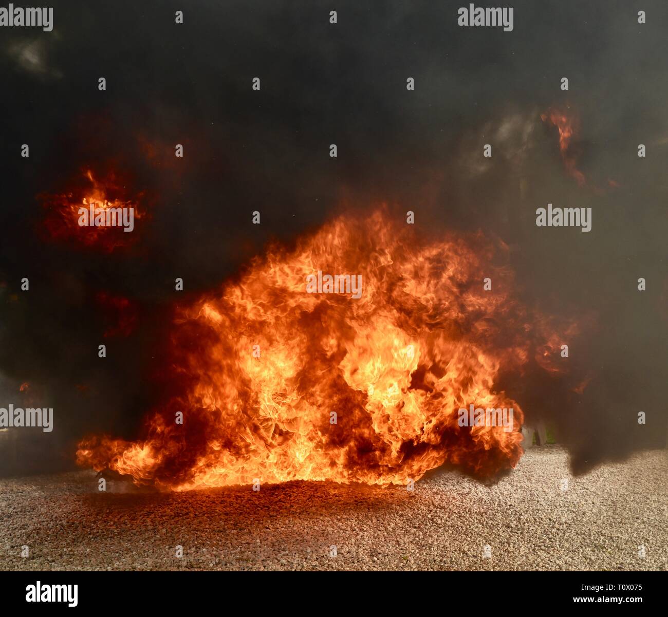 Explosive, dangerous inferno fire with undulating, dancing flames and blackening smoke rising