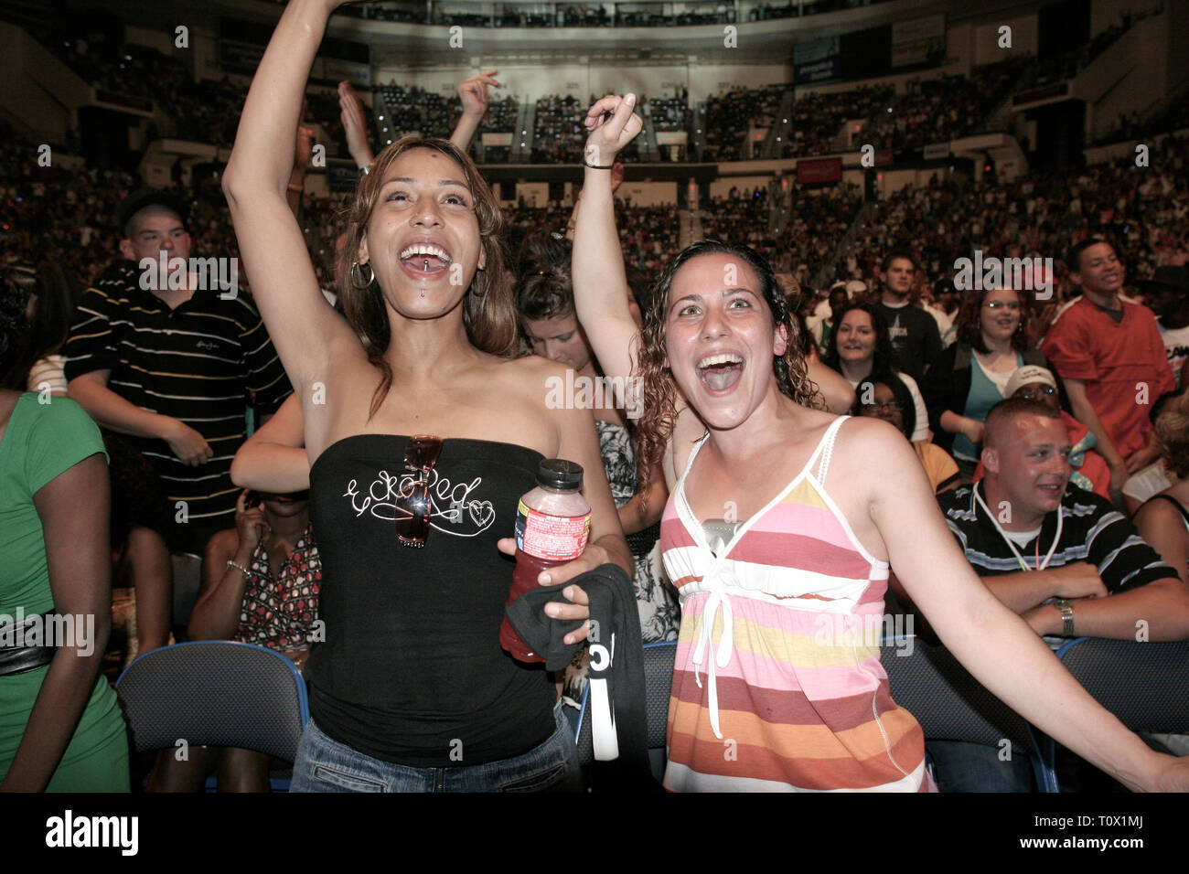 Front row concert fans are shown dancing to the music during a 'live' performance. Stock Photo