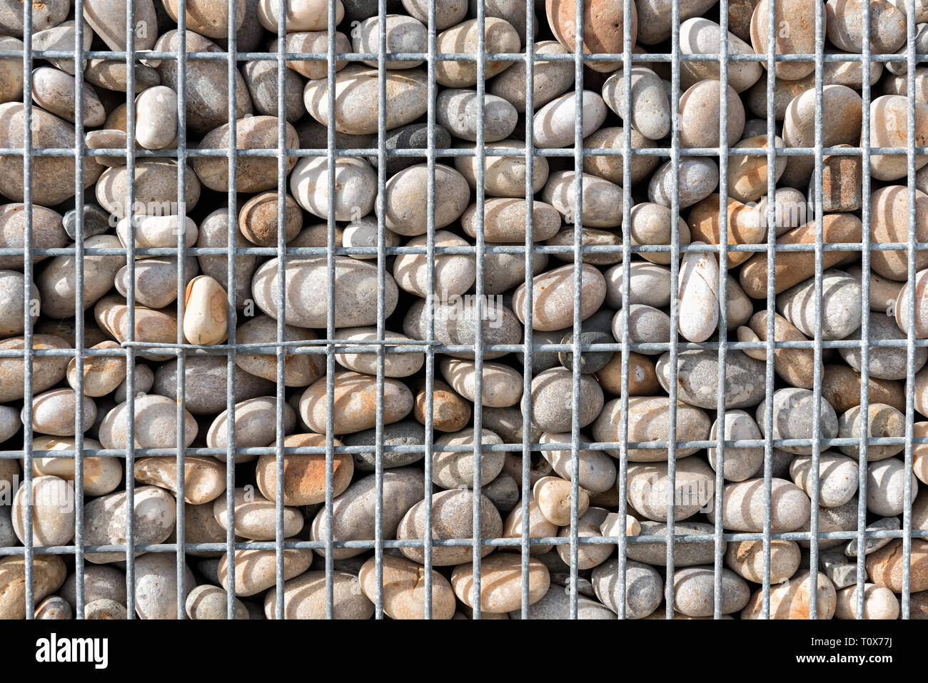 Close up of a gabion basket filled with pebbles Stock Photo - Alamy