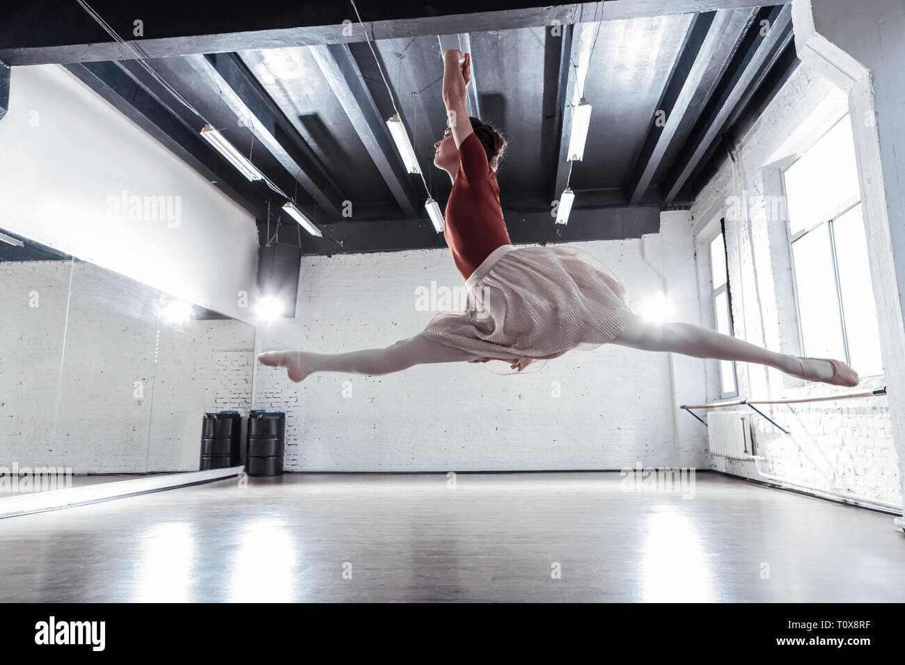 Beautiful skilled ballerina doing splits in the air Stock Photo