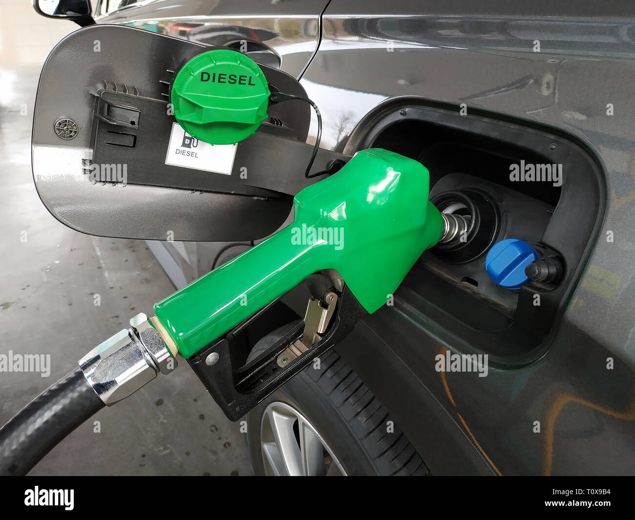 Fuel nozzles adding diesel fuel in car at a pump gas station. Stock Photo