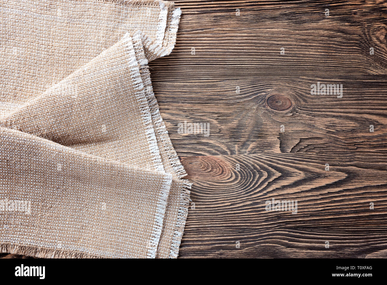 Linen napkin on a wooden table. View top. Background Stock Photo