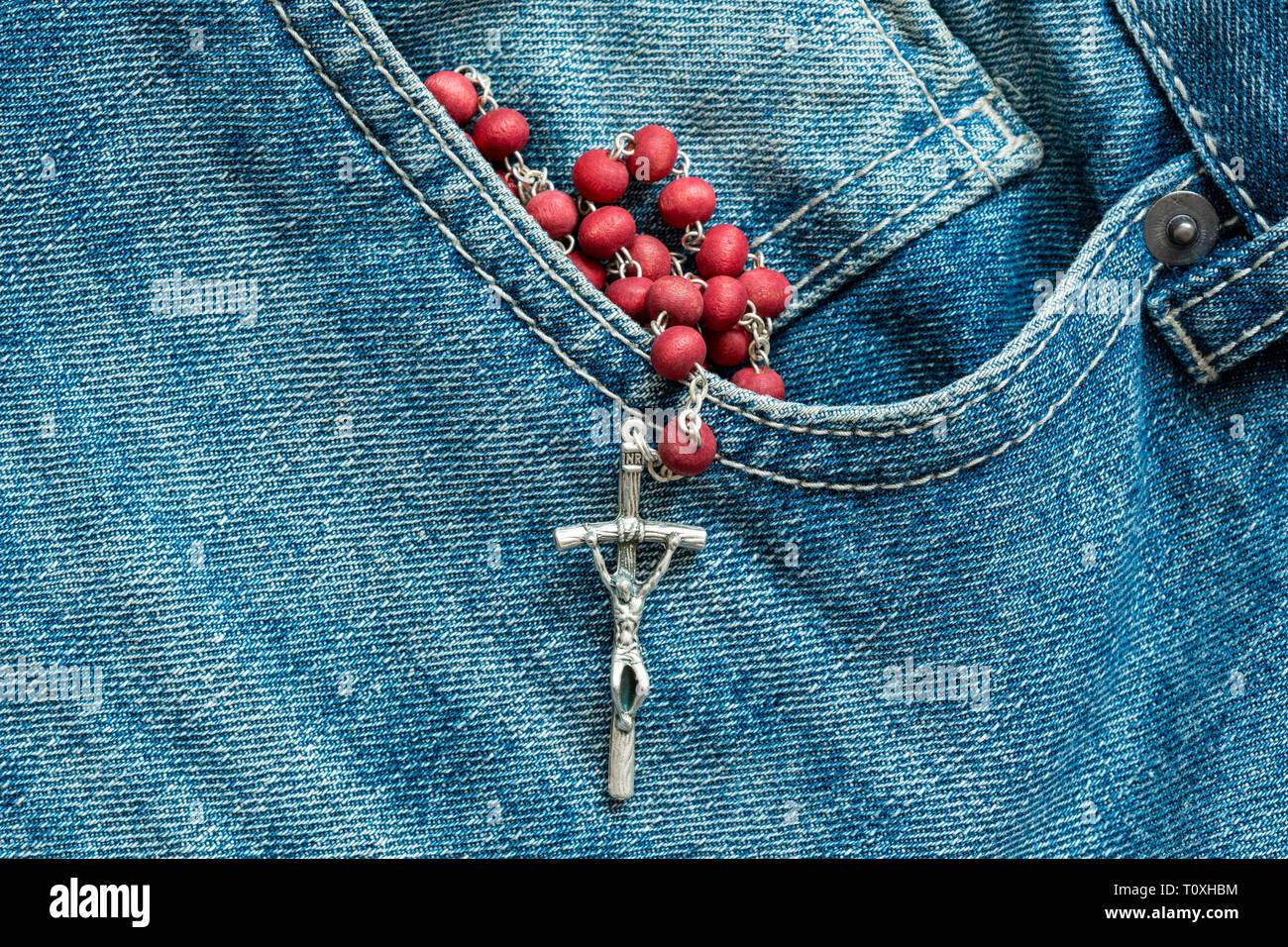 Catholic rosary in the pocket of the blue jeans Stock Photo - Alamy