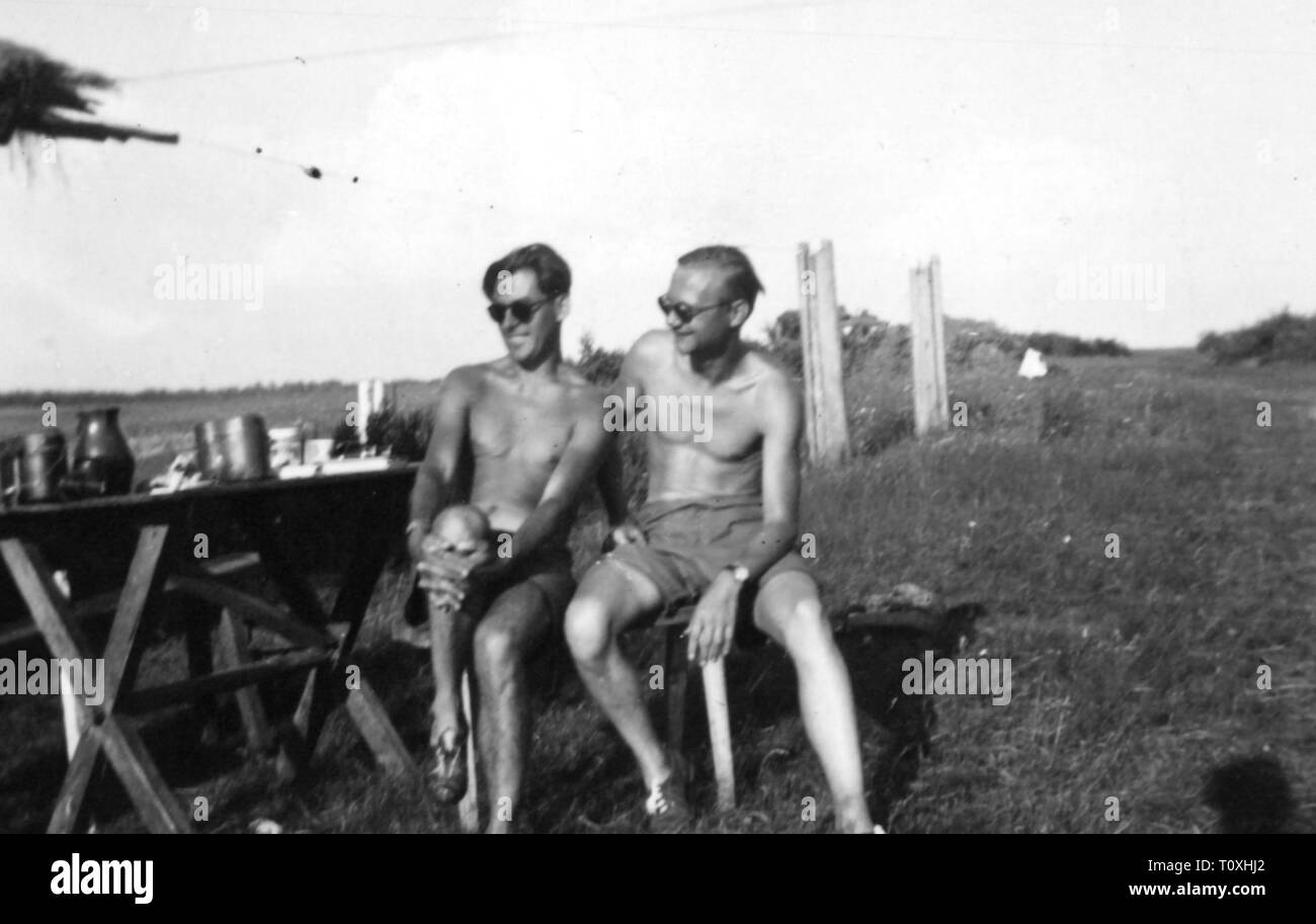 Second World War / WWII, Russia 1941, two members of the Luftwaffe War Correspondent Companie 3 sitting in the sun, July 1941, Operation Barbarossa, eastern front, soldiers, soldier, sun oneself, bask, sunning oneself, basking, cheerfulness, geniality, good mood, German Luftwaffe (German Air Force), war reporter, propaganda company, companies, propaganda corps, Wehrmacht, armed forces, people, 20th century, 1940s, second, 2nd, world war, world wars, members, member, sitting, sit, sun, suns, historic, historical, Additional-Rights-Clearance-Info-Not-Available Stock Photo