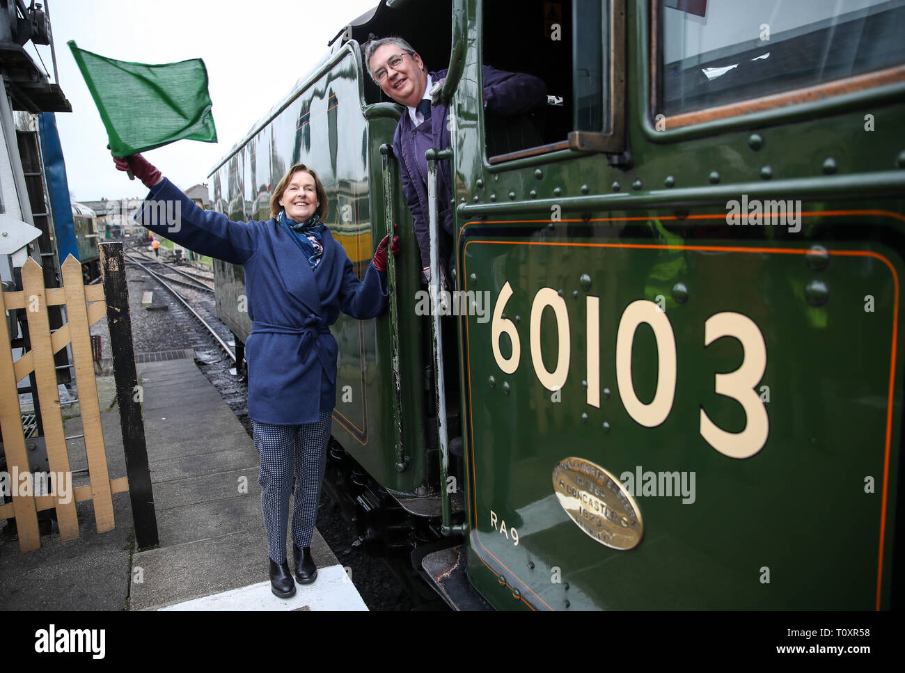 Penny Vaudoyer, the daughter of Alan Pegler who saved the Flying Scotsman from the scrap heap, at Swanage Railway in Dorset waving off the Flying Scotsman on its first trip. The Flying Scotsman was purchased by the National Railway Museum in 2004, and restored in a £4.2 million, ten-year project funded by the National Heritage Memorial Fund and the Heritage Lottery Fund as well as from public donations. Stock Photo
