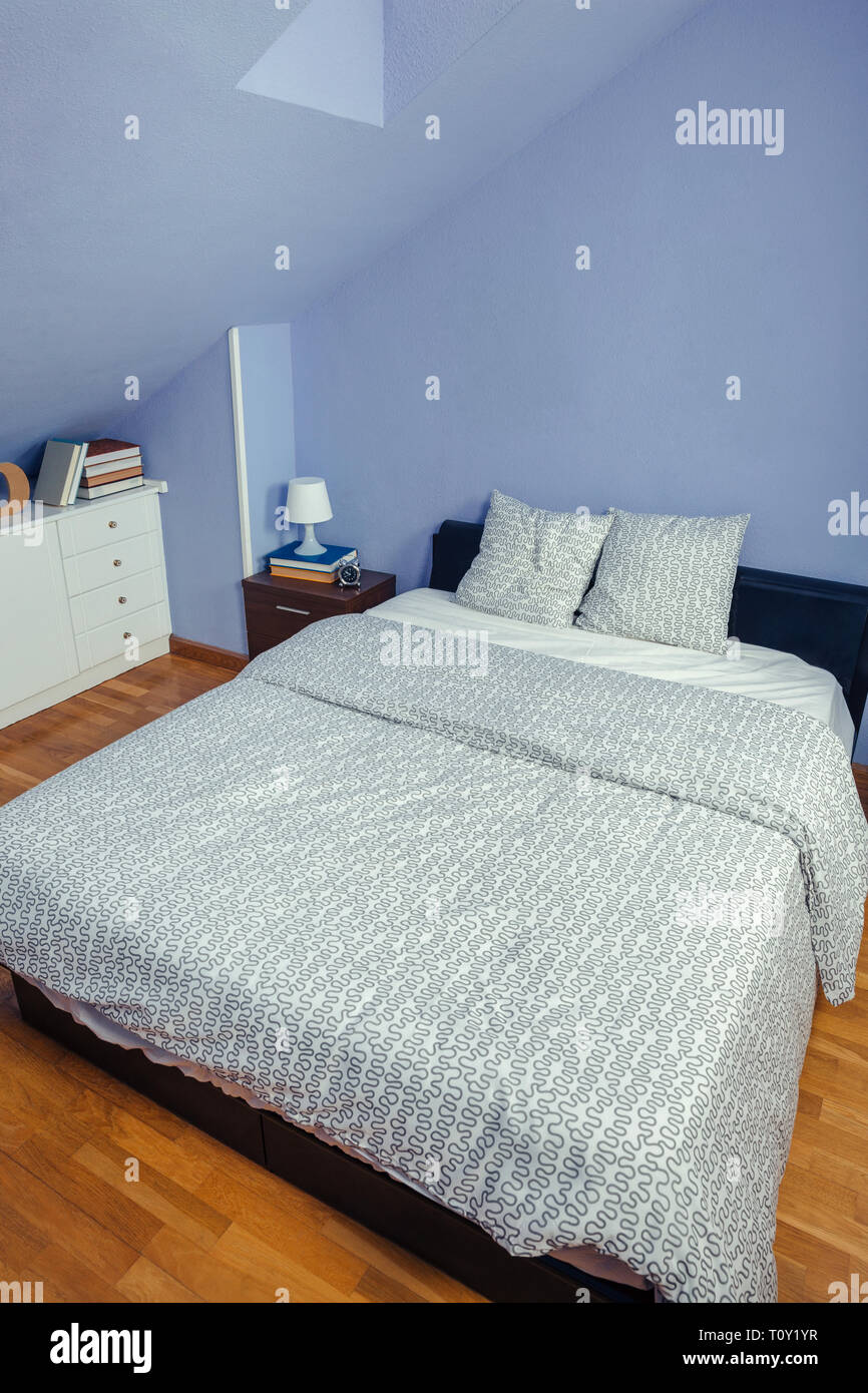 Bedroom in an attic with double bed Stock Photo