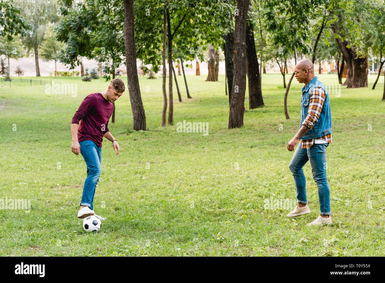 Multicultural friends playing soccer hi-res stock photography and ...