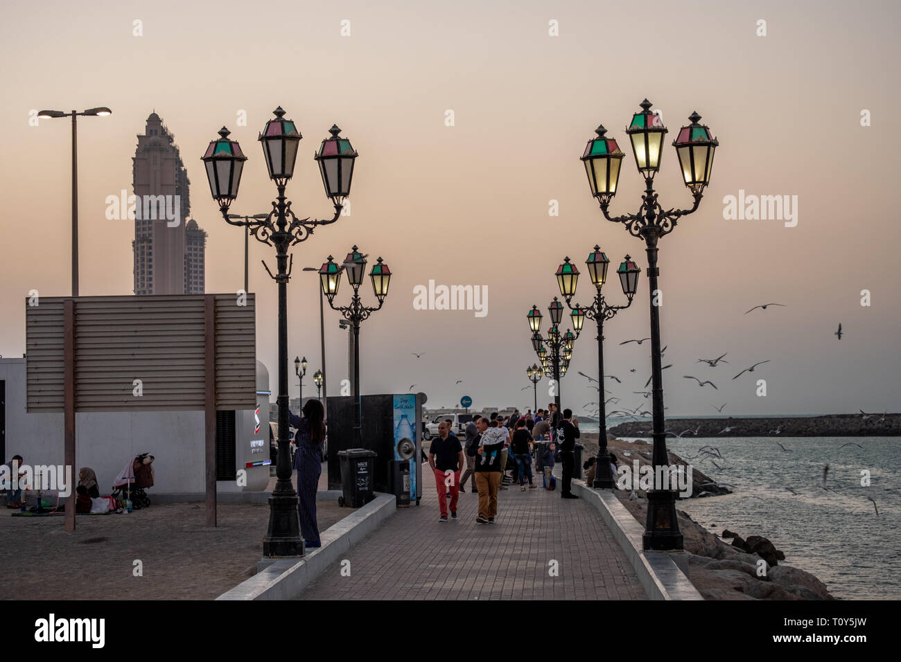 February 26, 2019 - Abu Dhabi, UAE: People enjoying at Cornich Marina lit with Lampost at evening, Abu Dhabi, UAE Stock Photo