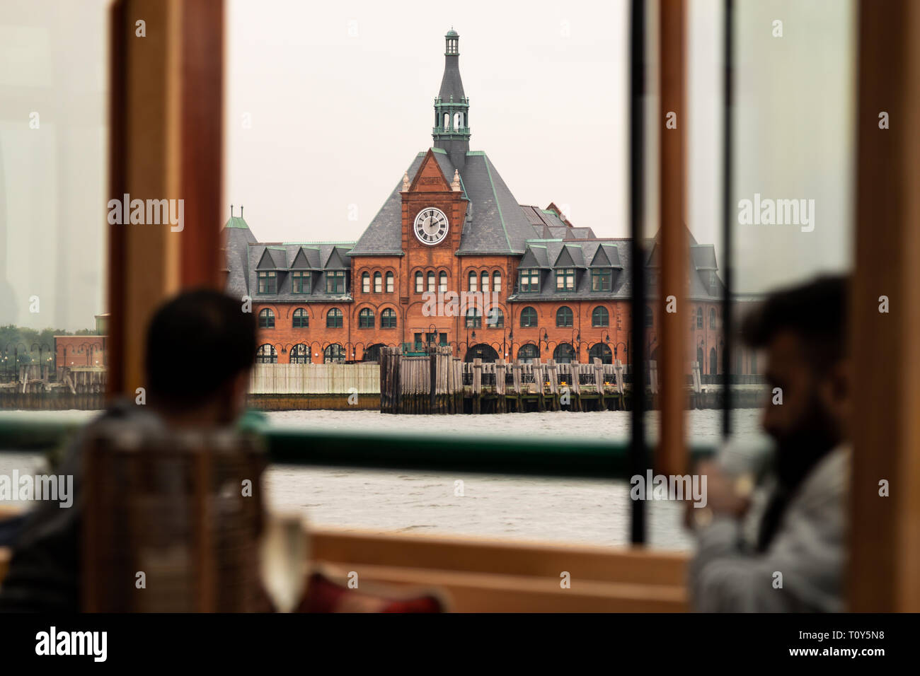 Tourists looking out the window of a boat on the river at the Central Railroad of New Jersey Terminal where ferries take people from New Jersey to Ellis Island to see the Statue of Liberty. Stock Photo