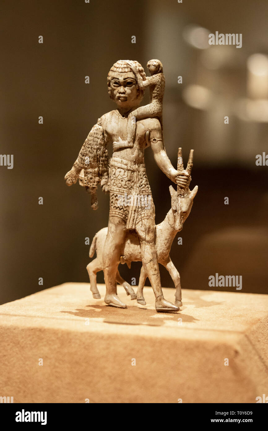 Statuette of a man with an oryx, a monkey, and a leopard skin is a small Neo-Assyrian ivory sculpture from the 8th century B.C. found in Nimrud is on display at the Metropolitan Museum of Art in New York City. Stock Photo