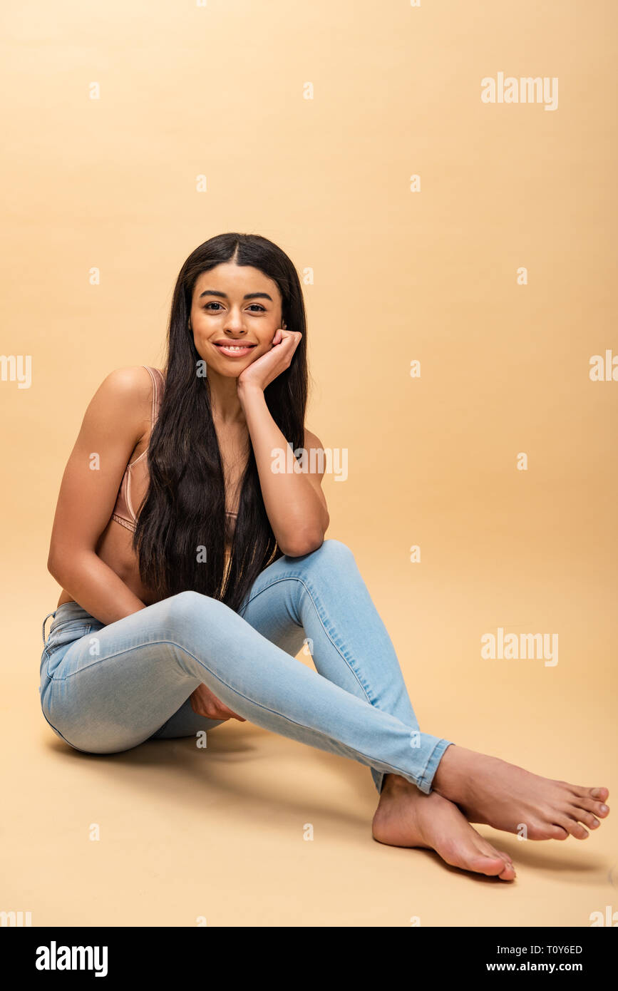 beautiful african american girl sitting with crossed legs and looking at camera Stock Photo