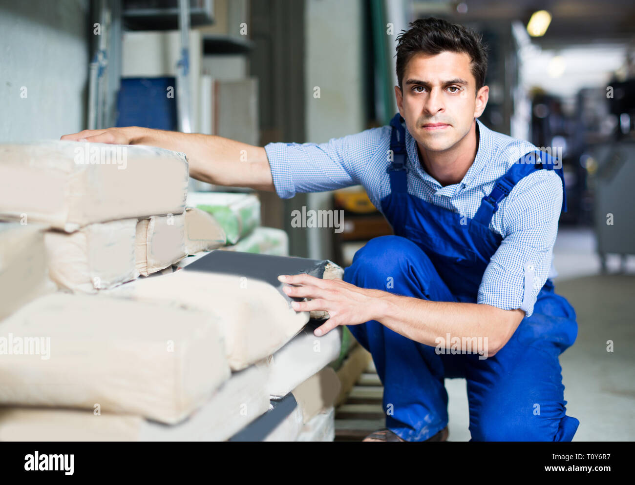 Shop assistant is checking bags with cement in the building store. Stock Photo