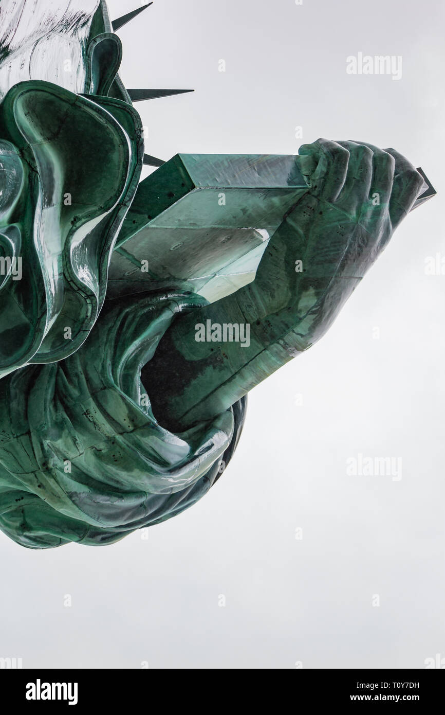 A close up of a rain-wet Statue of Liberty focussing on her robes, book and crown. Stock Photo
