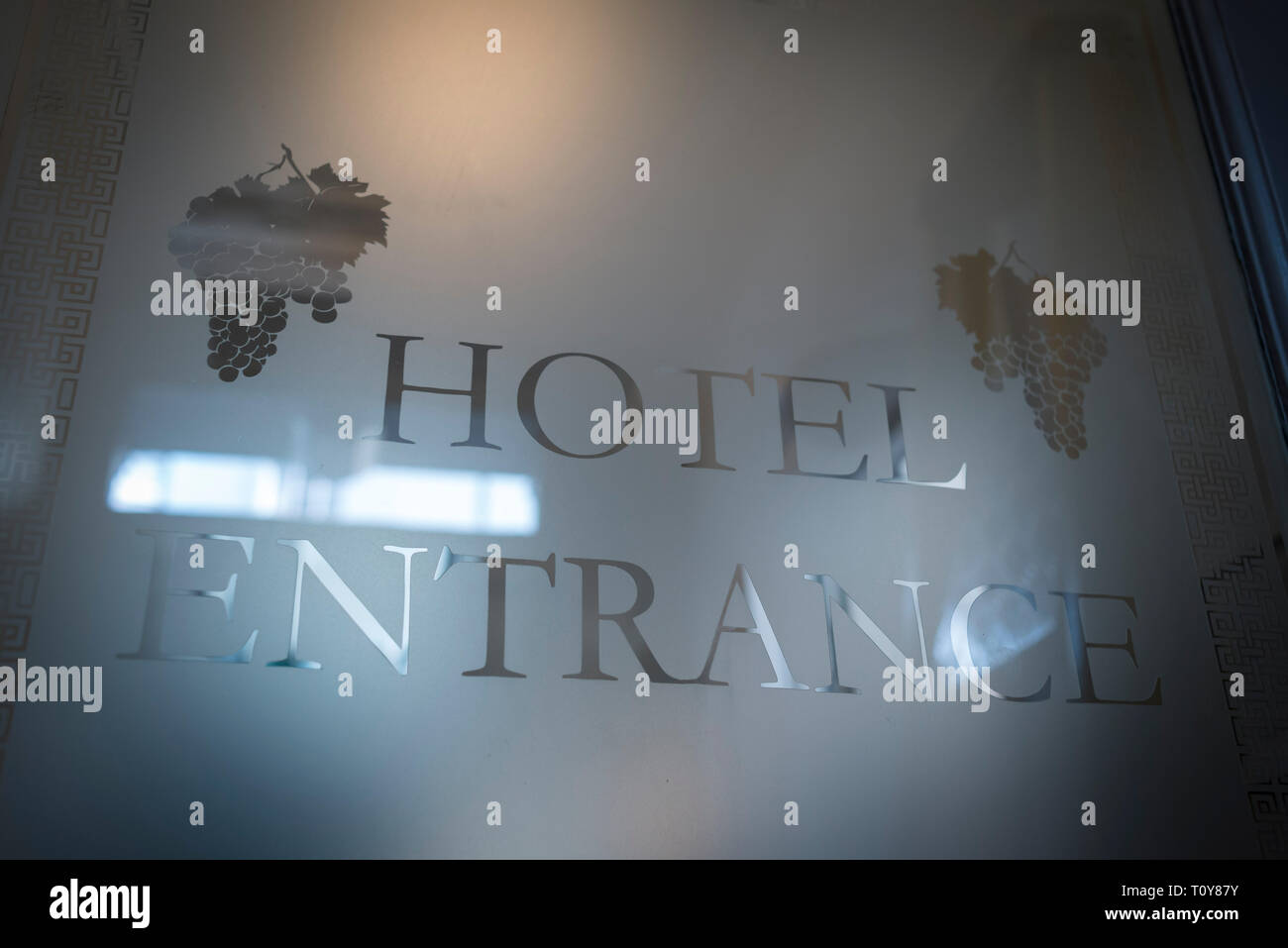 frosted etched glass above a hotel door saying hotel entrance Stock Photo