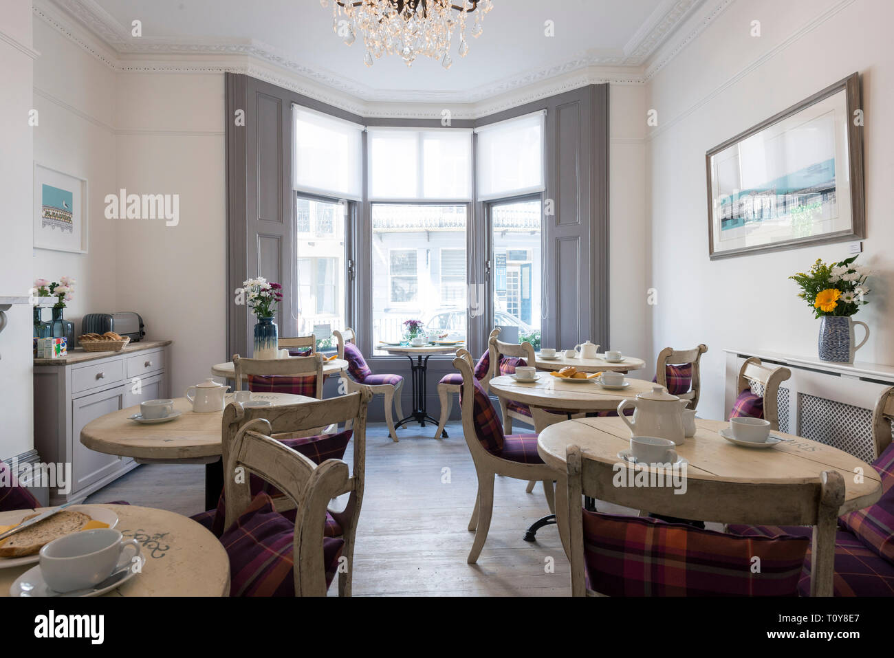 a dining room in a bed and breakfast hotel is laid out for breakfast Stock Photo