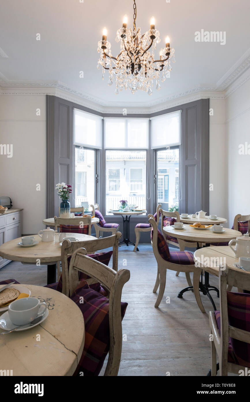 a dining room in a bed and breakfast hotel is laid out for breakfast Stock Photo