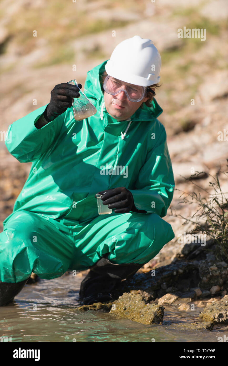 Water quality inspector filling up sample container with river water
