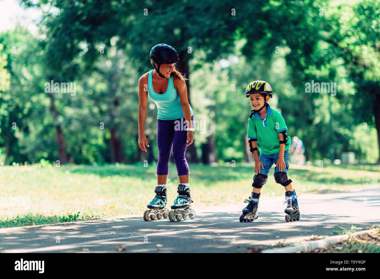 Двое учеников стоя на роликовых коньках держаться. Двое учеников стоя на роликовых коньках держаться. Кататься на роликовых коньках. Мужчина и женщина на роликах. Мужчина и женщина на роликах.