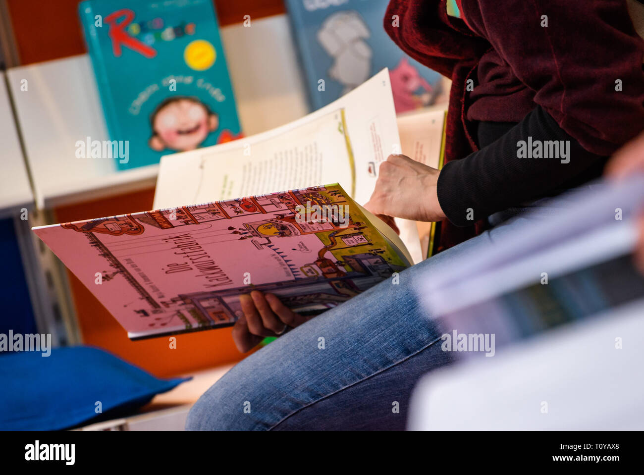 Leipzig, Germany. 21st Mar, 2019. A visitor reads a book at the booth of Klett during the 2019 Leipzig Book Fair in Leipzig, Germany, March 21, 2019. The four-day Leipzig Book Fair kicked off on Thursday, attracting over 2,500 exhibitors from more than 50 countries and regions all over the world. Credit: Kevin Voigt/Xinhua/Alamy Live News Stock Photo