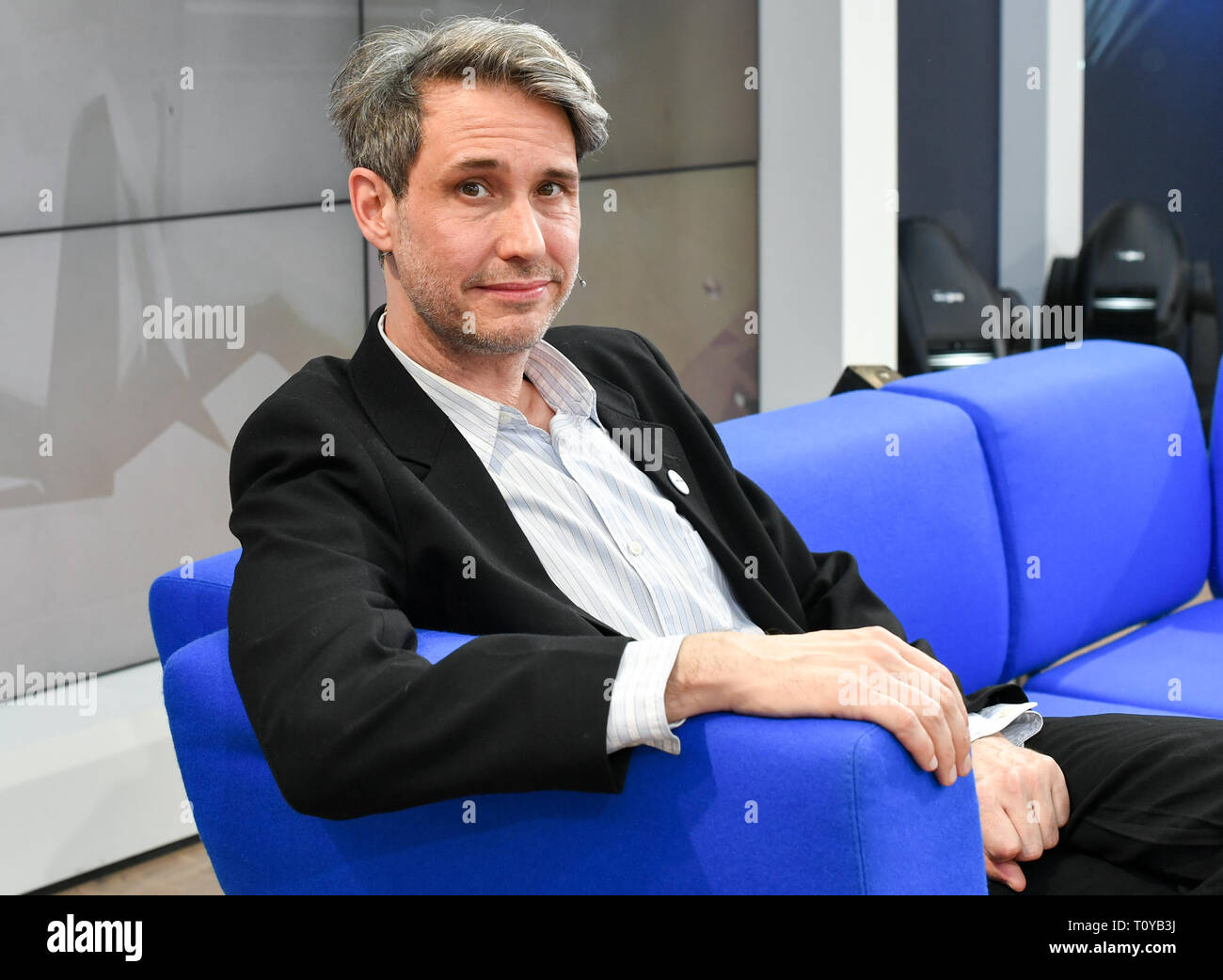 Leipzig, Germany. 22nd Mar, 2019. Dirk von Lowtzow, singer of the band Tocotronic, presents his book 'Aus dem Dachsbau' on the blue sofa. Until 24.03.2019 about 2600 exhibitors will present themselves on the exhibition grounds. At the same time the festival 'Leipzig reads' invites to numerous readings. The guest country of the Book Fair this year is the Czech Republic. Credit: Jens Kalaene/dpa-Zentralbild/dpa/Alamy Live News Stock Photo