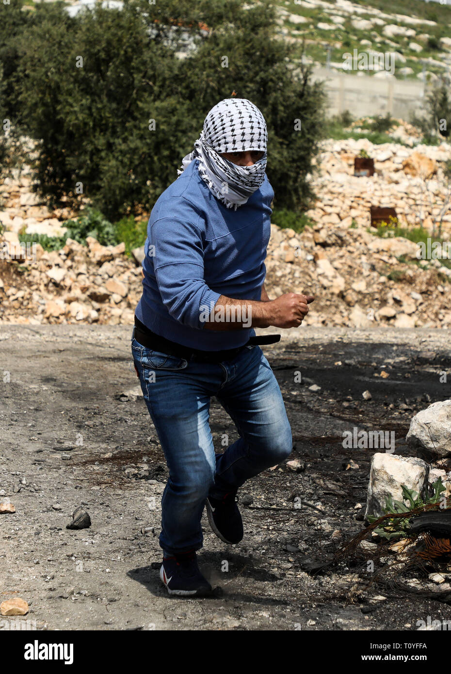 Qalqilya, West Bank, 22th March 2019. Cashes occur between Palestinian demonstrators and the Israeli army in the West Bank town of Kafr Qaddum. Since 2003, the road between Kafr Qaddum and Nablus has been blocked to Palestinians and left open only to Israeli settlers and the Israeli army although an Israeli court ruled the roadblock illegal. The roadblock makes it impossible for Palestinians to reach their farmlands by car and lengthens the distance to Nablus of 14 Km. Credit: ZUMA Press, Inc./Alamy Live News Stock Photo