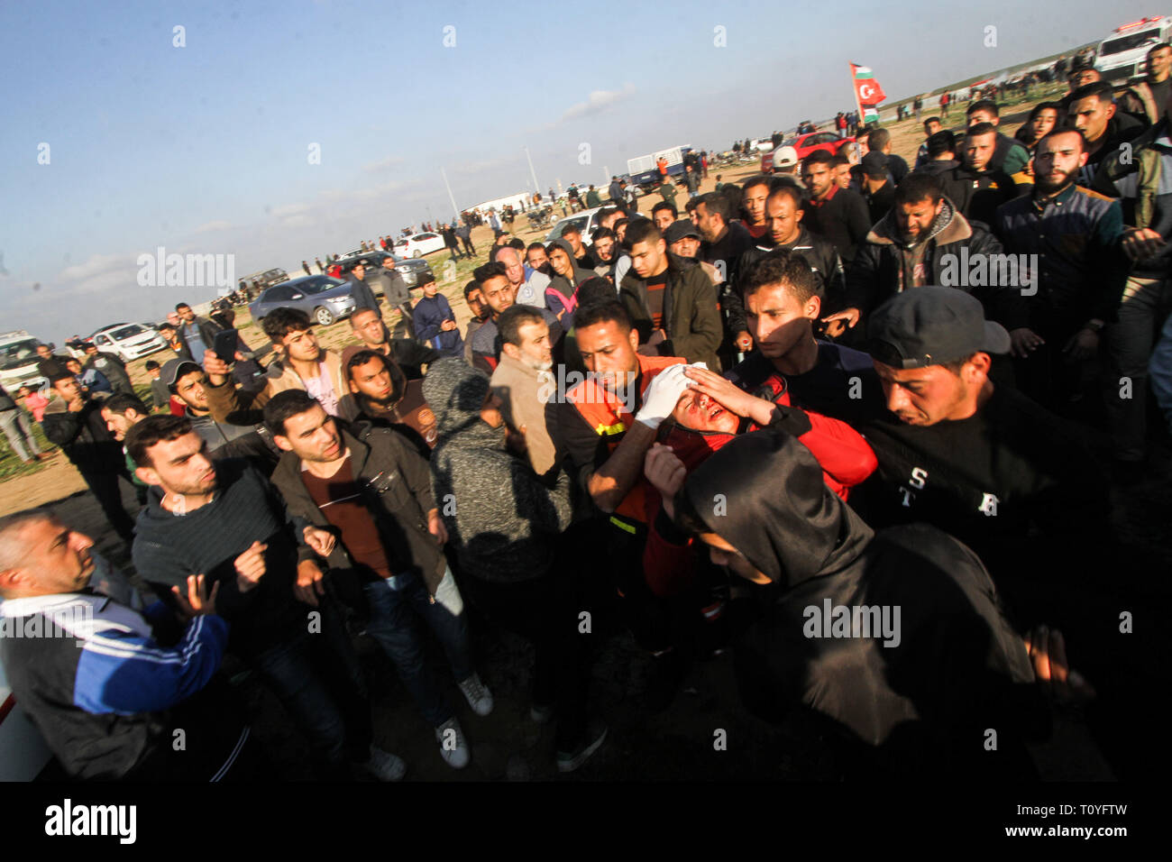 March 22, 2019 - Gaza, 22th March 2019. A number of Palestinian demonstrators are injured in clashes with the Israeli army in the Malika district on the east of Gaza City during this Friday 51st Great March of Return rally. Thousands of demonstrators had gathered at several points on the Gaza-Israeli borders with some hurling rocks and burning tires, and with Israeli troops firing live ammunition, rubber-coated steel bullets, and tear gas at protesters. According to the Gaza Health Ministry, 30 Palestinians were shot and injured by Israeli live fire, while dozens of others suffered from tear-g Stock Photo